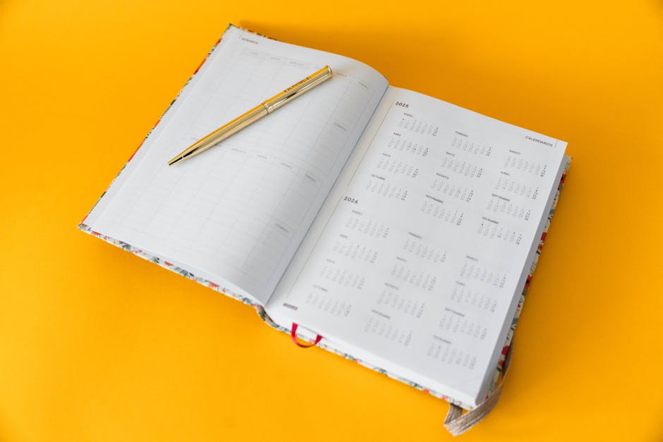 A minimal open planner with handwritten notes and a pen resting beside it, soft natural lighting