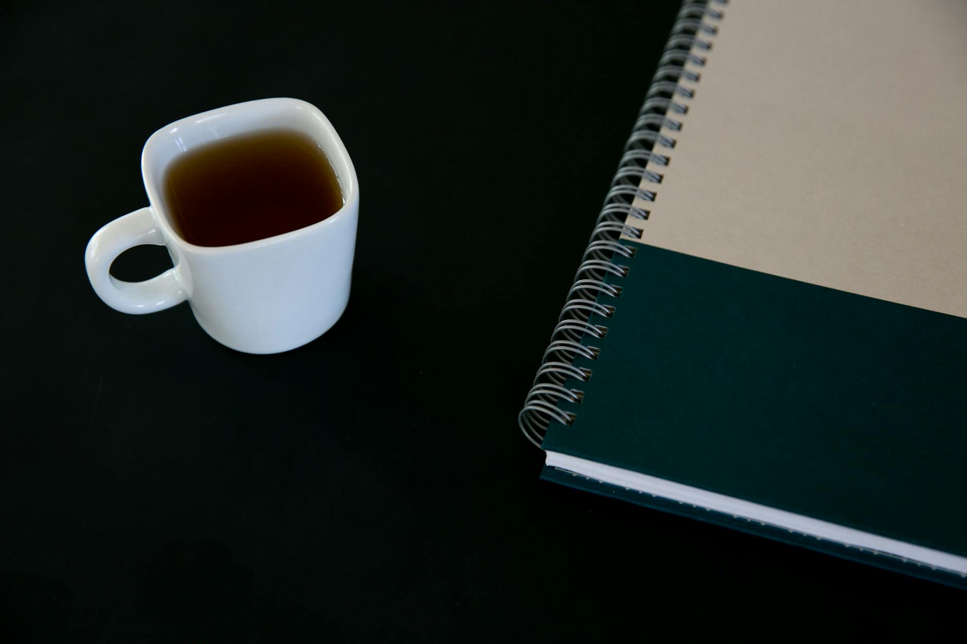A person sitting peacefully at a clean desk with tea and a calm phone interface — serene morning