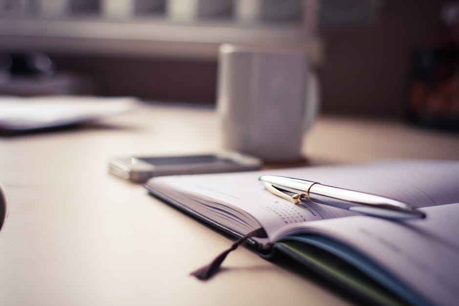 A close-up of an iPhone showing a daily planner app, next to a coffee cup on a wooden table with soft morning light