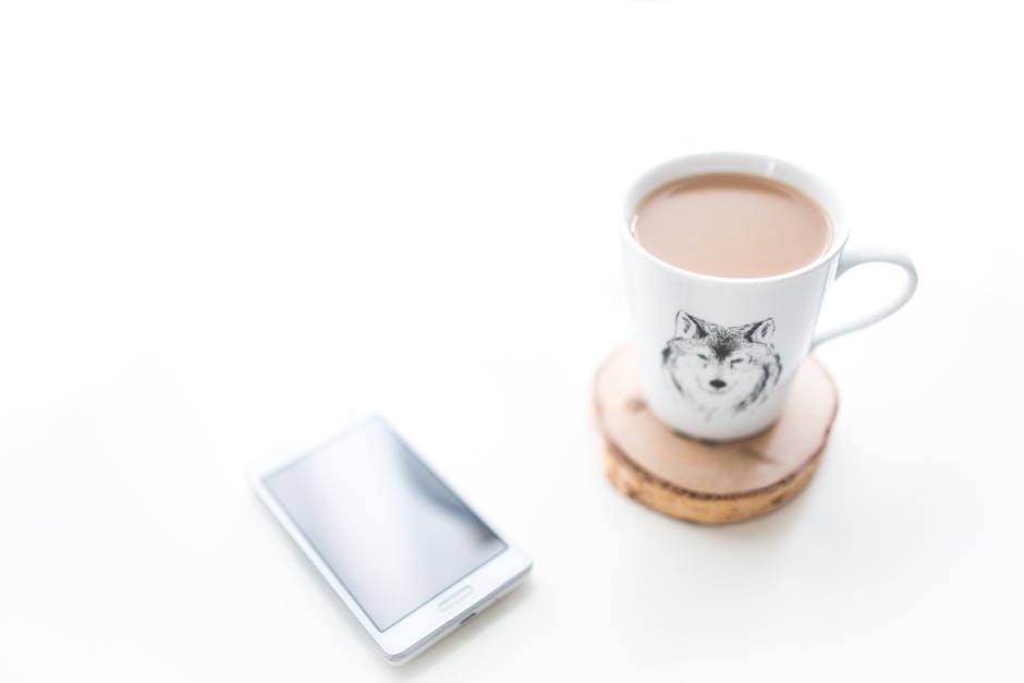 A calm morning desk setup with coffee, a phone, and sunlight — a sense of peaceful readiness