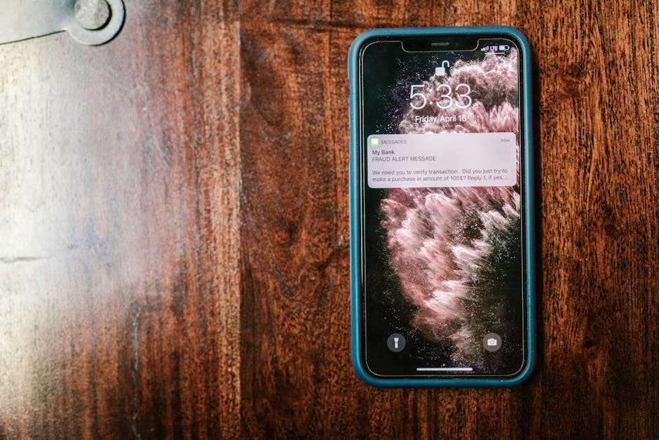 An iPhone resting on a wooden table with a soft notification visible on screen, warm natural light