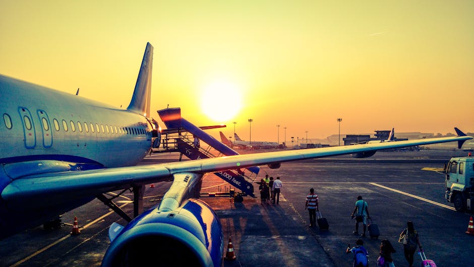 A calm airport terminal in soft morning light with a traveler walking toward the gate