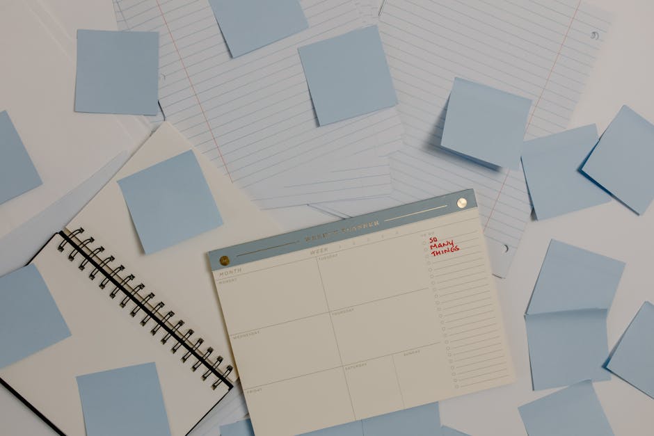 Several colorful sticky notes arranged around an open weekly planner on a white desk