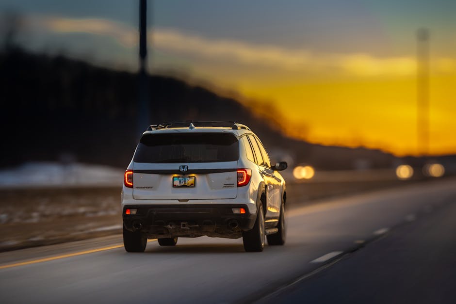 An empty highway stretching toward the horizon under a golden sunset sky