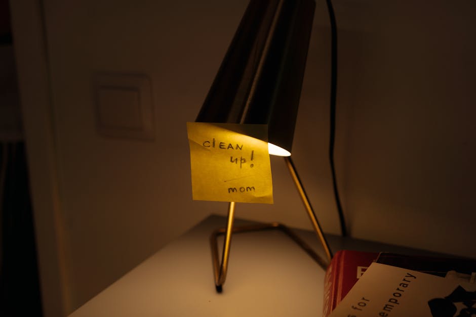 A tidy desk with a closed notebook and warm lamp light at the end of the day