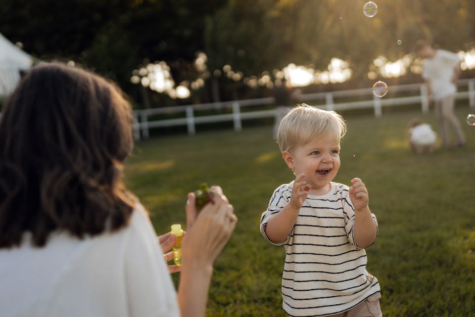 A family sitting together outside on grass in afternoon light, laughing and relaxed