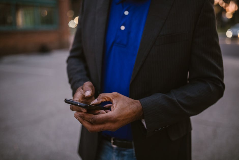 A person looking at their phone while sitting on outdoor steps in warm afternoon light