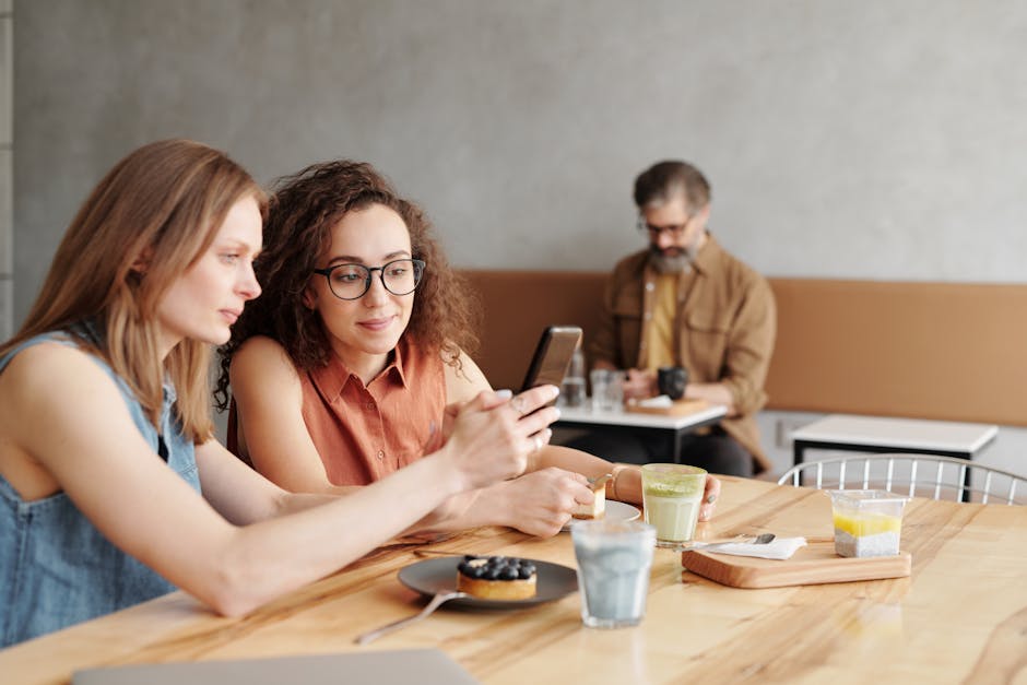 Friends gathered together planning an event, phones and coffee on the table